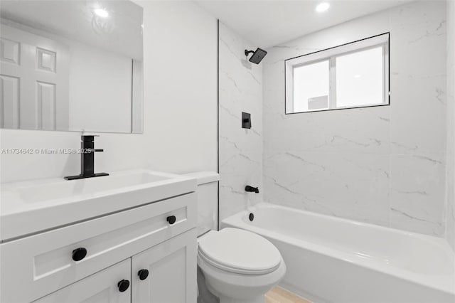 full bathroom with tiled shower / bath, vanity, and toilet