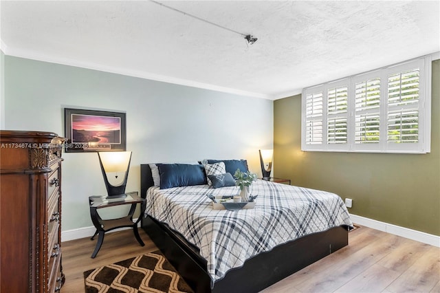 2851 Somerset Dr Unit 415, Lauderdale Lakes, FL 33311 - bedroom featuring baseboards, wood finished floors, a textured ceiling, and ornamental molding