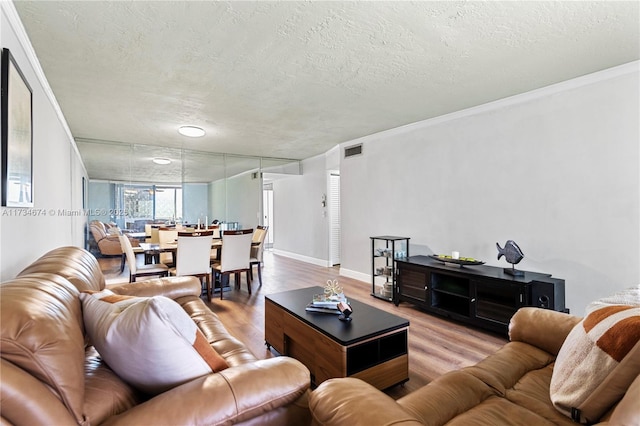 2851 Somerset Dr Unit 415, Lauderdale Lakes, FL 33311 - living room with wood finished floors, a textured ceiling, crown molding, and baseboards