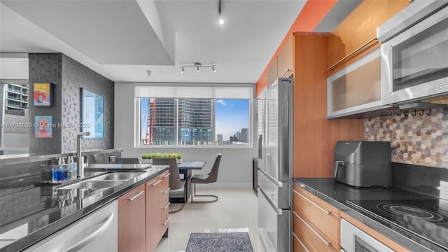 kitchen with rail lighting, appliances with stainless steel finishes, sink, and plenty of natural light