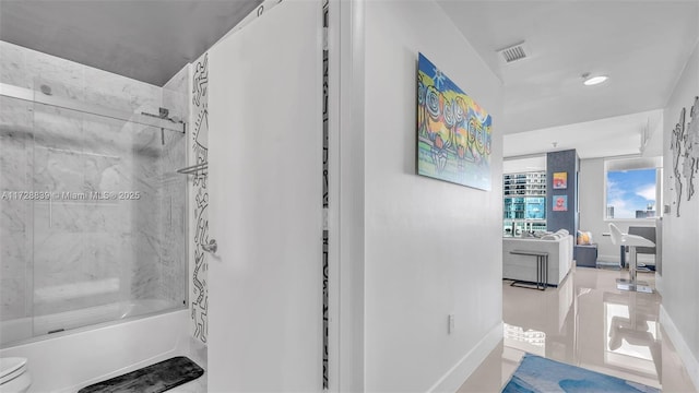 bathroom with tiled shower / bath and toilet