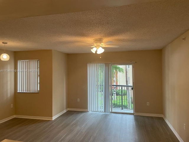 empty room featuring a textured ceiling, dark hardwood / wood-style floors, and ceiling fan