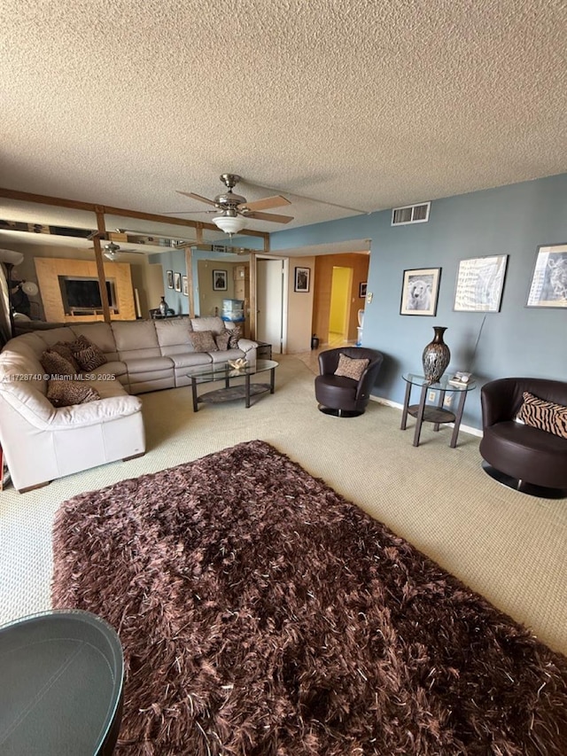 carpeted living room with ceiling fan and a textured ceiling