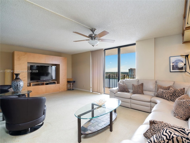 living room with carpet floors, ceiling fan, a wall of windows, and a textured ceiling