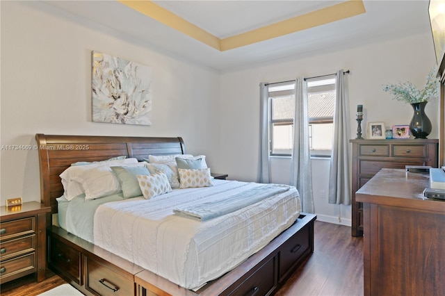 bedroom featuring dark wood-type flooring and a tray ceiling