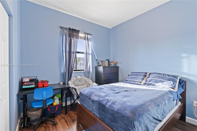 bedroom with dark hardwood / wood-style floors