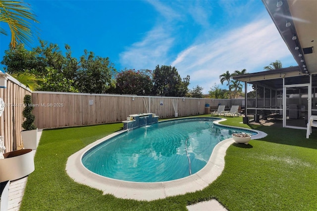 view of pool with pool water feature, a sunroom, and a lawn