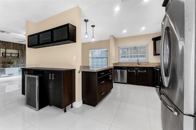 kitchen featuring stainless steel appliances, sink, light tile patterned floors, and decorative light fixtures