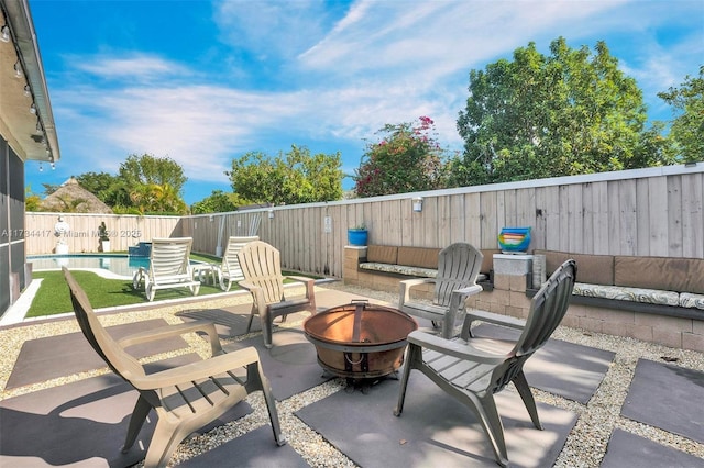 view of patio / terrace featuring a fenced in pool and a fire pit