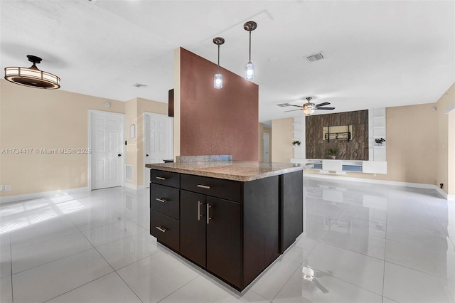 kitchen with dark brown cabinetry, hanging light fixtures, light tile patterned floors, a kitchen island, and ceiling fan