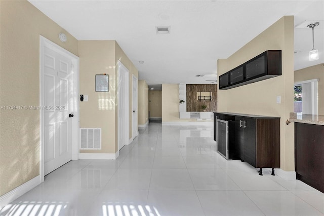 kitchen with hanging light fixtures, dark brown cabinets, and light tile patterned floors