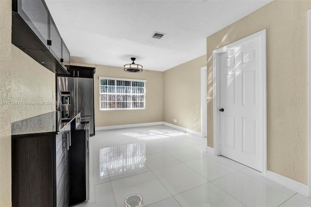 kitchen featuring tile patterned flooring and stainless steel fridge with ice dispenser