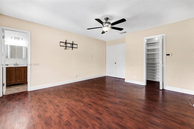 empty room with dark wood-type flooring, sink, a textured ceiling, and ceiling fan