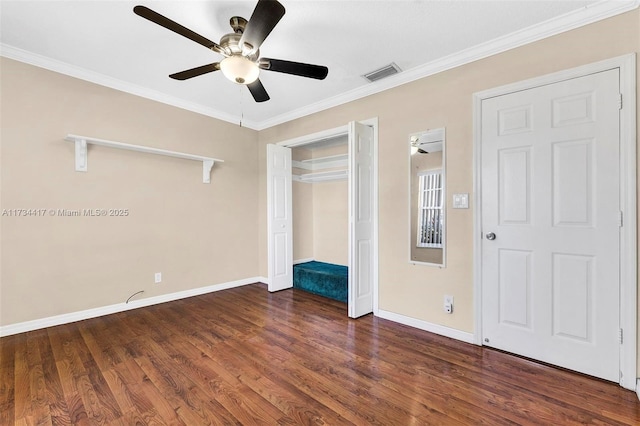 unfurnished bedroom featuring dark wood-type flooring, ornamental molding, and ceiling fan