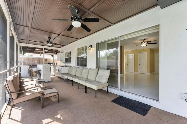 view of patio / terrace with exterior kitchen, exterior bar, an outdoor living space, and ceiling fan