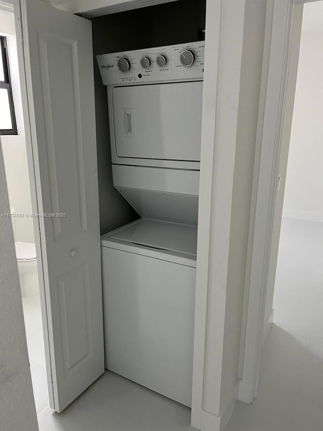 clothes washing area featuring stacked washer / drying machine