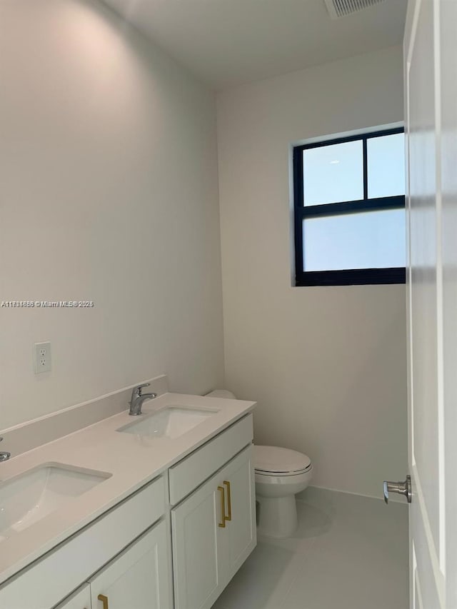 bathroom with vanity, tile patterned flooring, and toilet