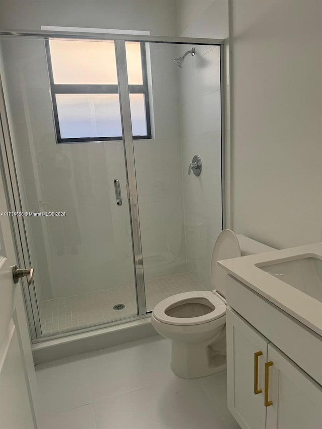 bathroom featuring vanity, toilet, tile patterned flooring, and a shower with door