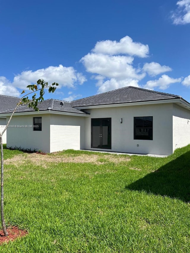 rear view of property featuring a yard