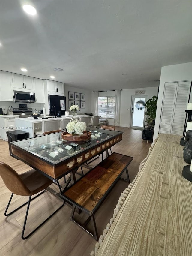 dining area with sink and light hardwood / wood-style floors