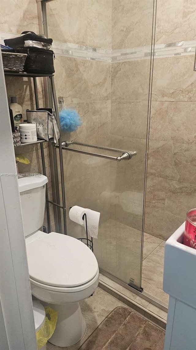 bathroom featuring tiled shower and toilet