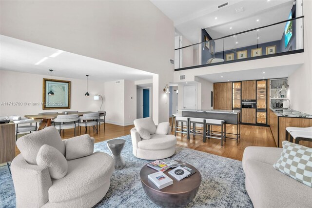 living room with hardwood / wood-style flooring and a high ceiling