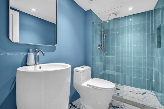 full bath featuring tiled shower, marble finish floor, and toilet