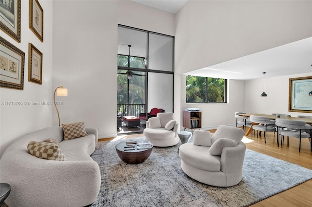 living room with wood finished floors and a towering ceiling