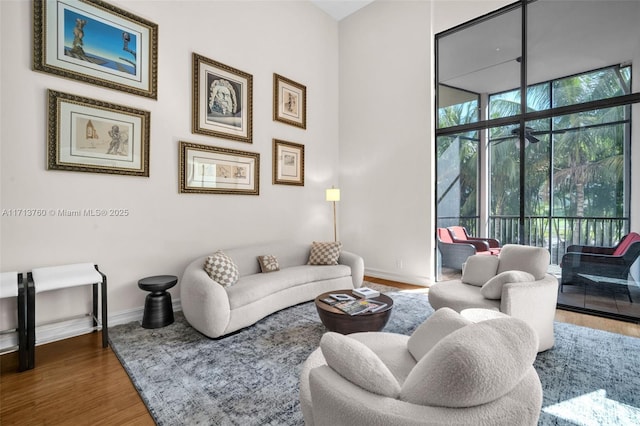 living area with baseboards and wood finished floors