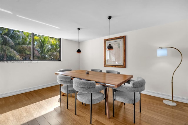 dining space with wood finished floors and baseboards