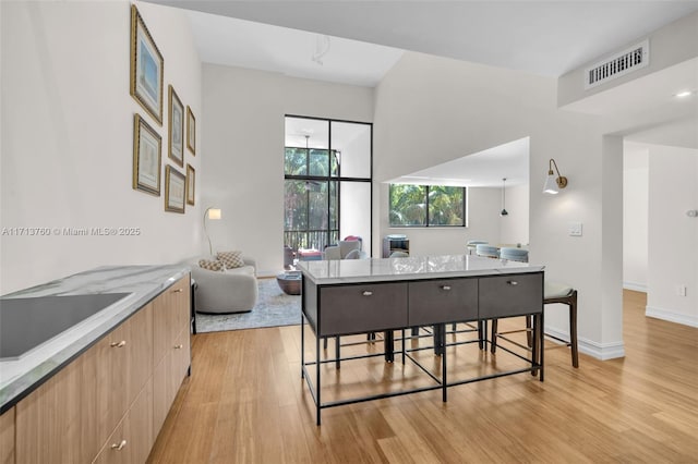 dining area featuring visible vents, light wood-type flooring, and baseboards