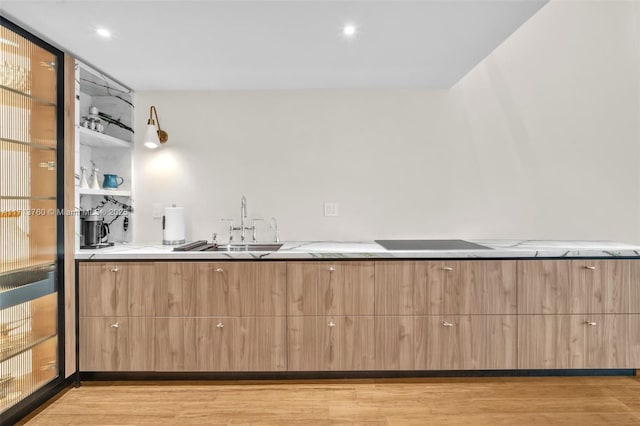 bar featuring light wood-type flooring and black electric stovetop