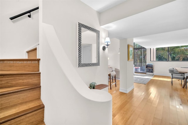 staircase featuring wood finished floors and baseboards