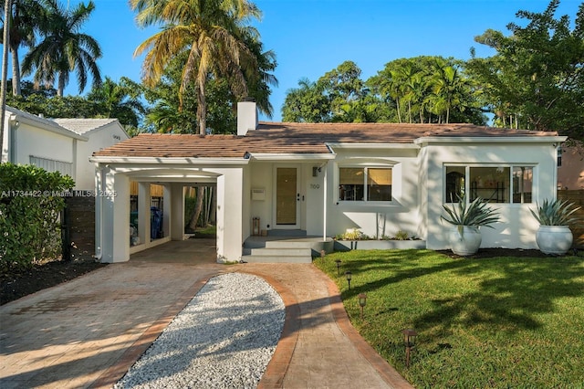 view of front facade with a front lawn and a carport