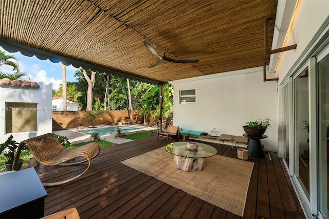 wooden deck with ceiling fan and a fenced in pool