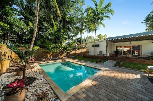 view of swimming pool with a wooden deck and a patio area