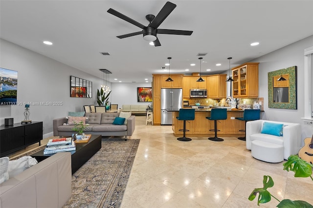 living room featuring ceiling fan and sink