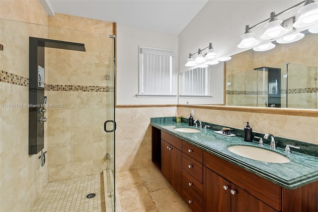 bathroom featuring walk in shower, vanity, and tile walls