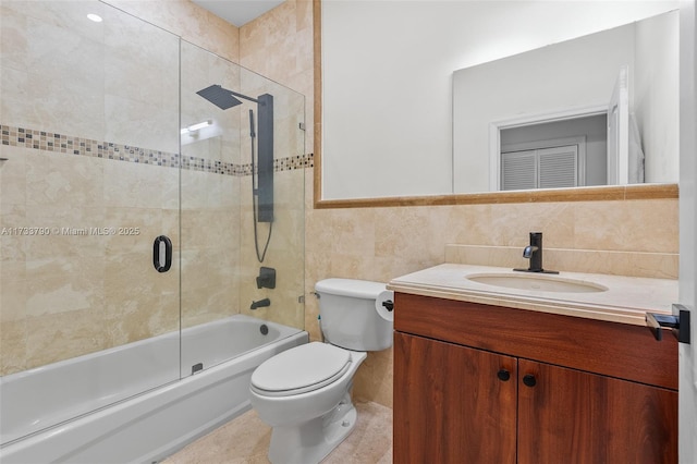 full bathroom with tile walls, enclosed tub / shower combo, vanity, toilet, and tile patterned floors