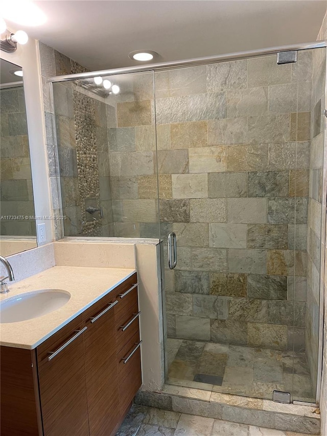 bathroom featuring walk in shower and vanity