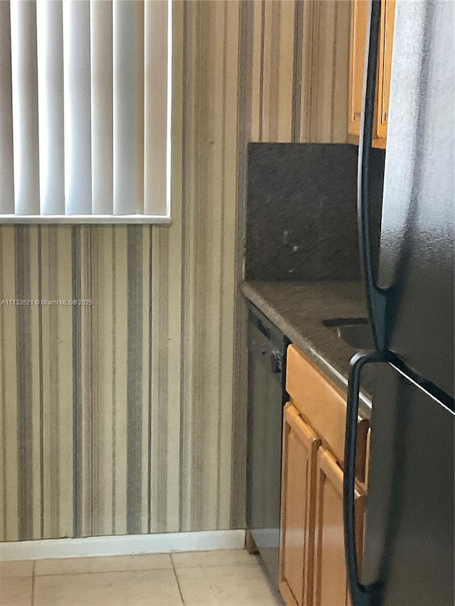 kitchen featuring black refrigerator and light tile patterned floors