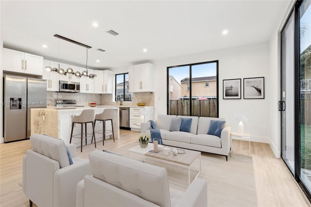 living room with sink and light hardwood / wood-style flooring