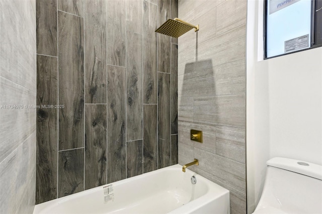 bathroom featuring tiled shower / bath and toilet