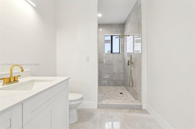 bathroom featuring vanity, toilet, and tiled shower