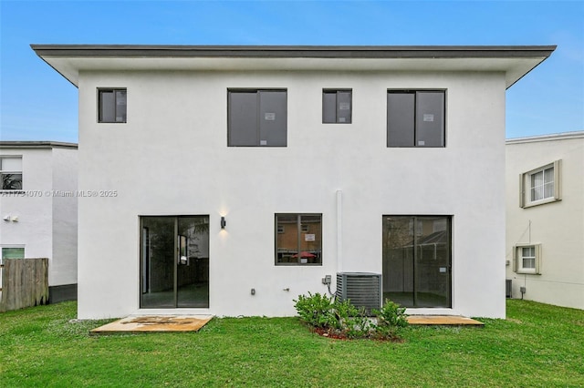 rear view of property featuring central AC and a yard