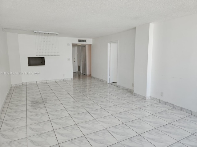 unfurnished room featuring a textured ceiling