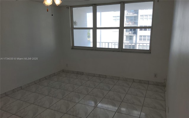 unfurnished room featuring light tile patterned floors and ceiling fan