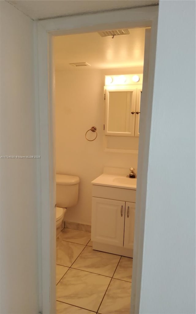 bathroom with vanity, tile patterned floors, and toilet