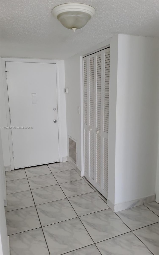 corridor featuring a textured ceiling