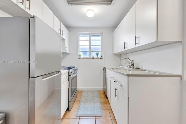 kitchen featuring stainless steel appliances, white cabinetry, sink, and light tile patterned floors